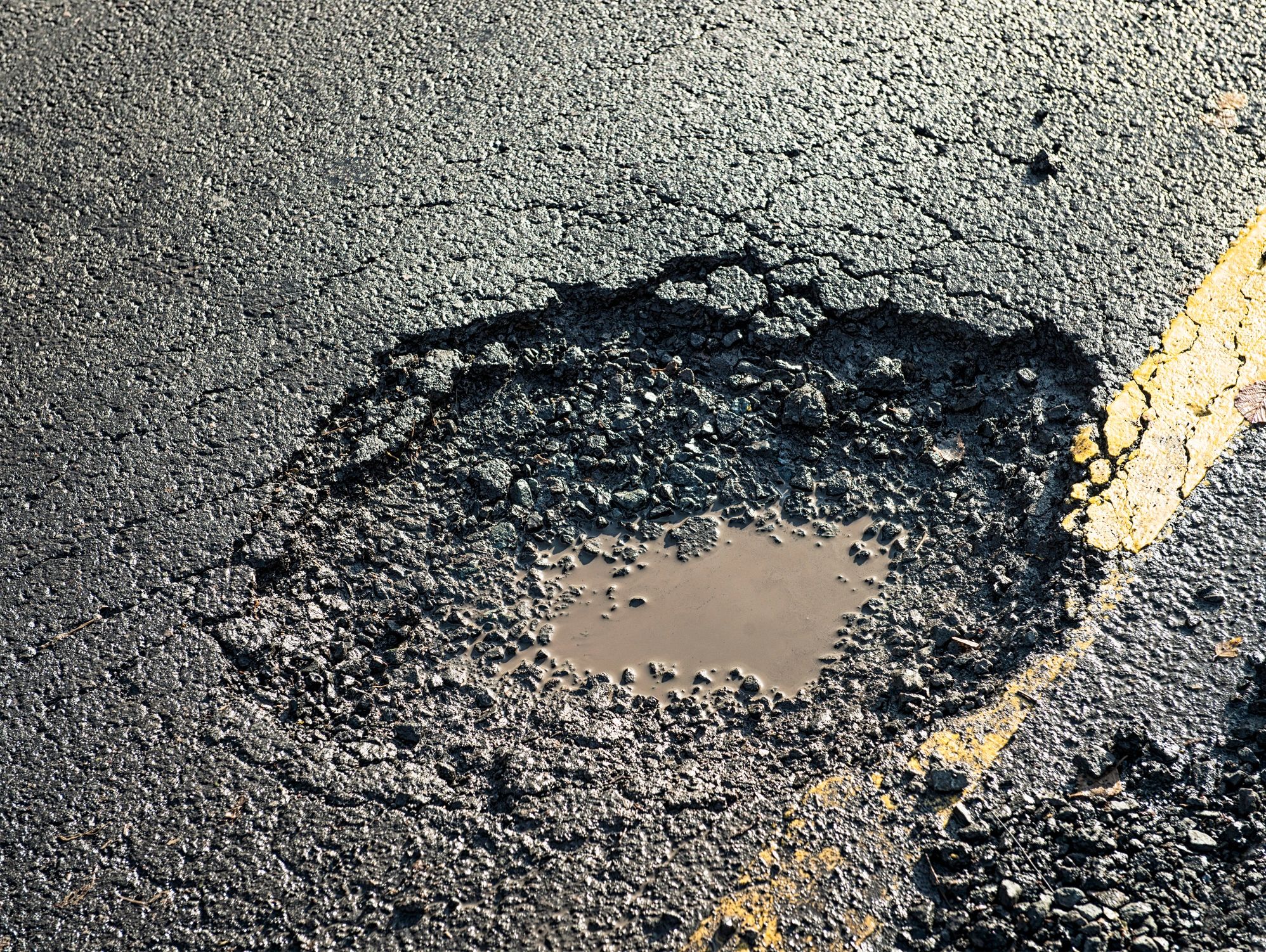 Close-up of a pothole in a road surface