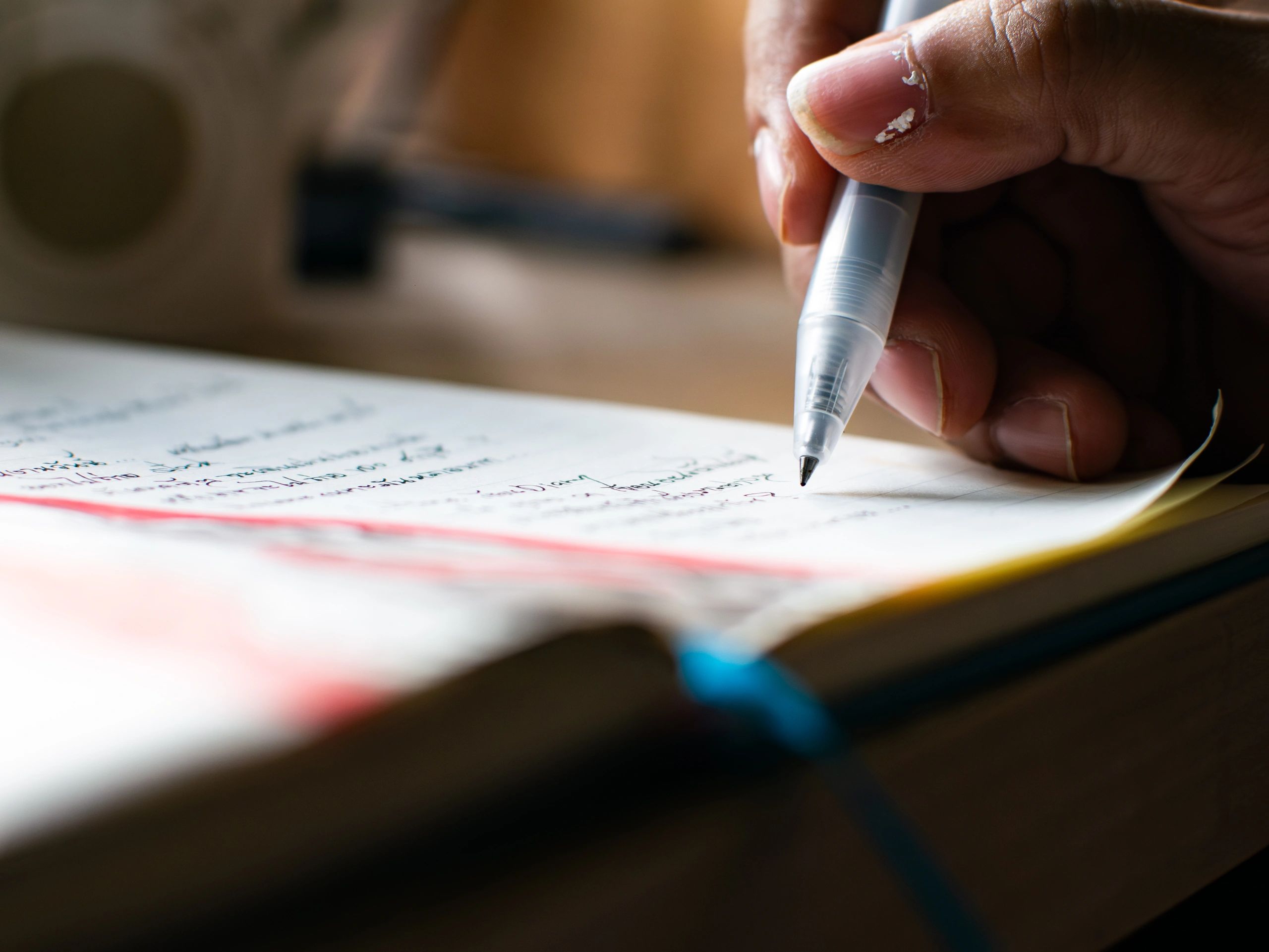 Hand writing notes on a form in a notebook