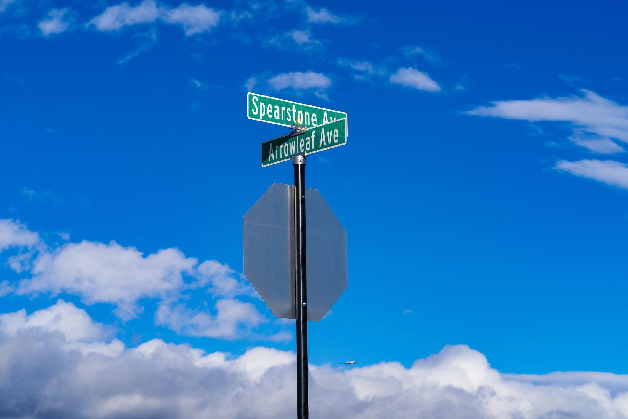 Street sign at an intersection against a blue sky