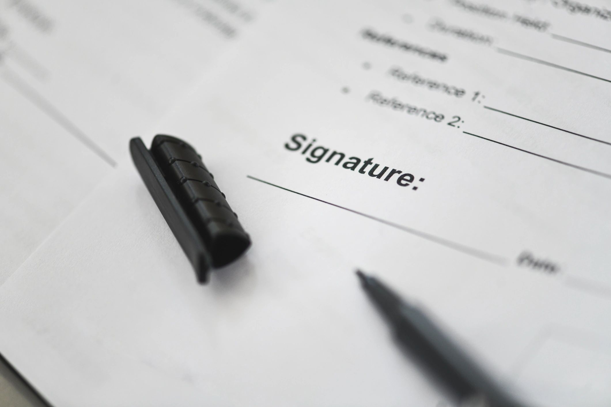 Pen poised to sign a document on a desk